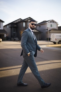 A man in a suit walking across a street