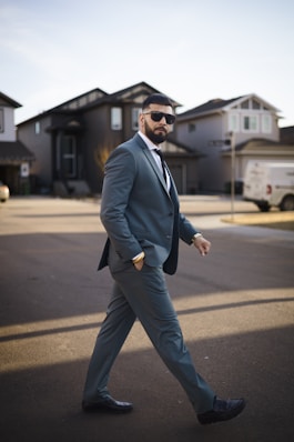 A man in a suit walking across a street
