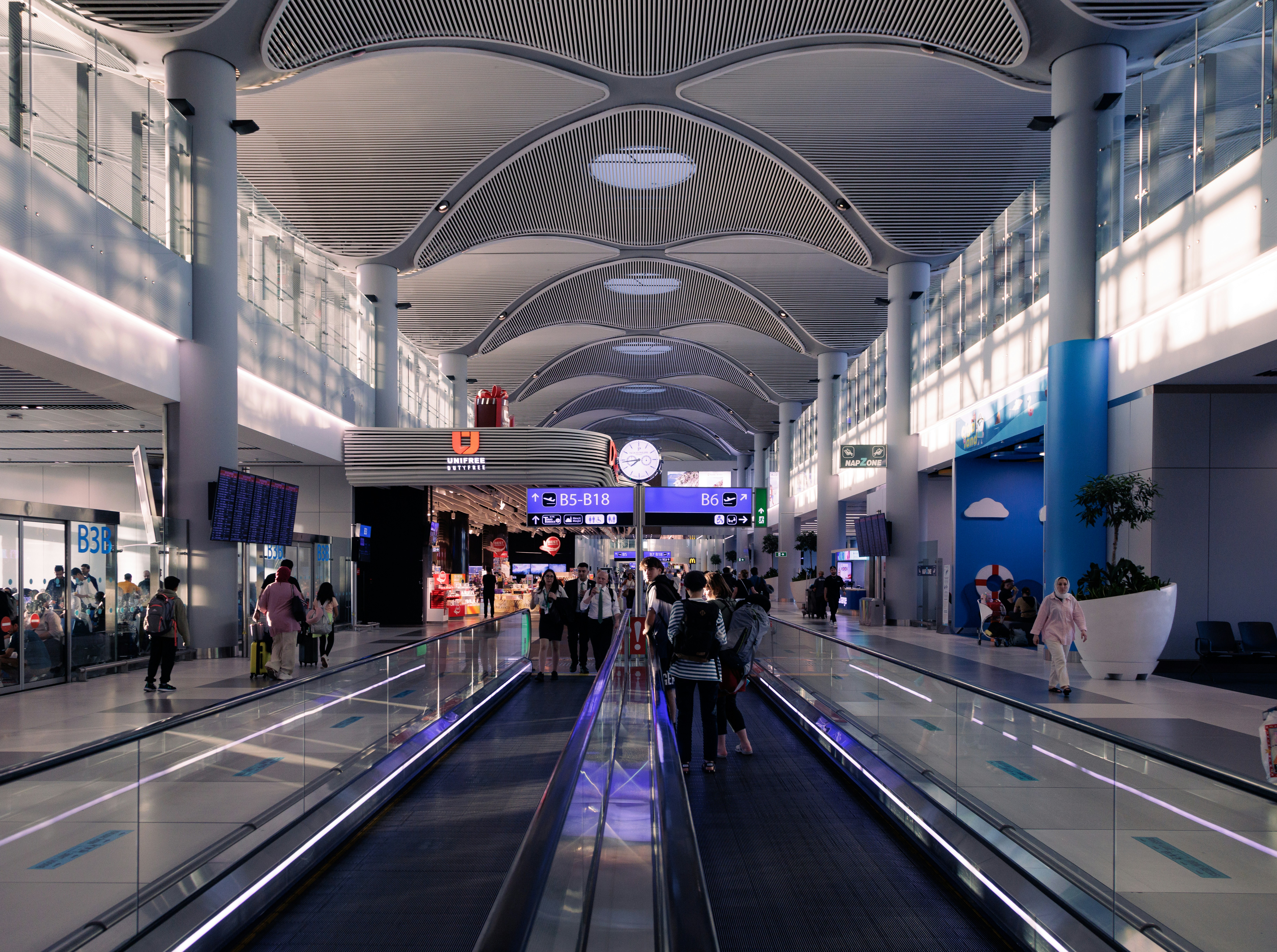 A group of people walking through an airport, 