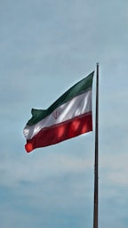 A flag flying in the wind with a blue sky in the background
