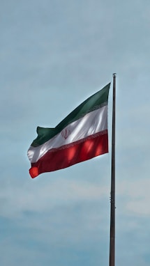 A flag flying in the wind with a blue sky in the background