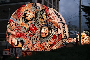 A large decorated umbrella sitting on the side of a road