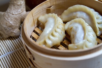 A wooden basket filled with dumplings on top of a table