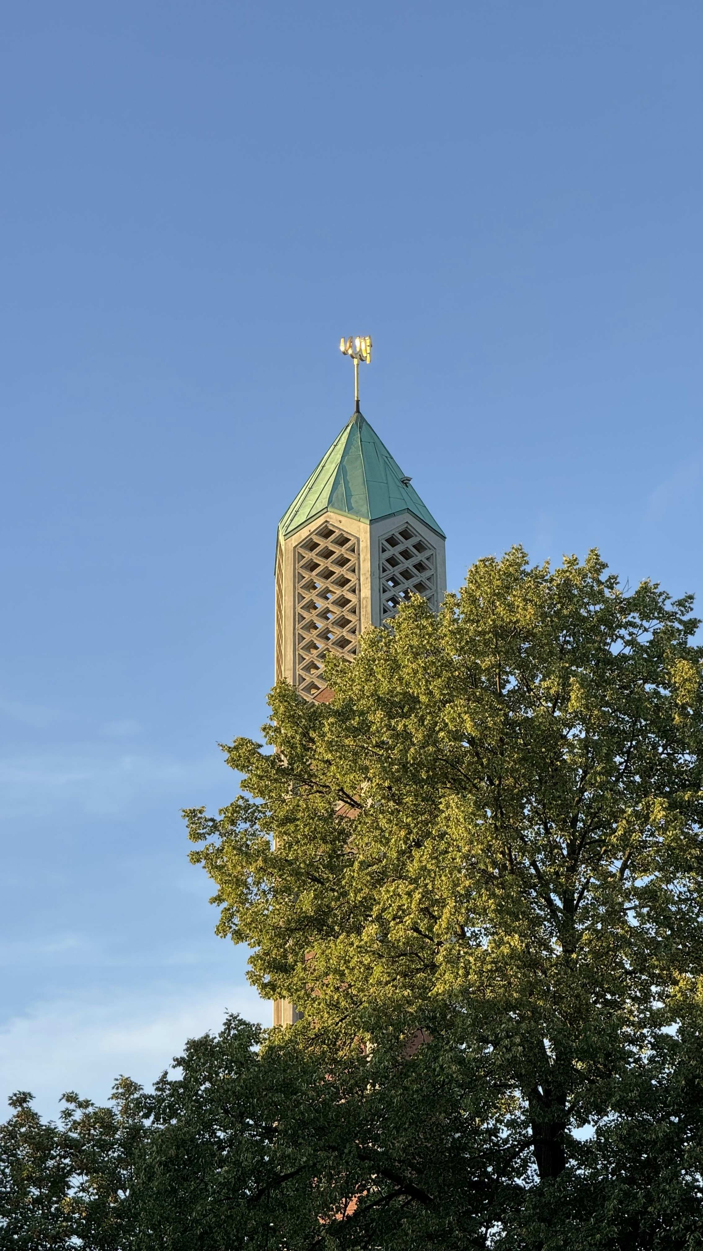 A tall tower with a cross on top of it