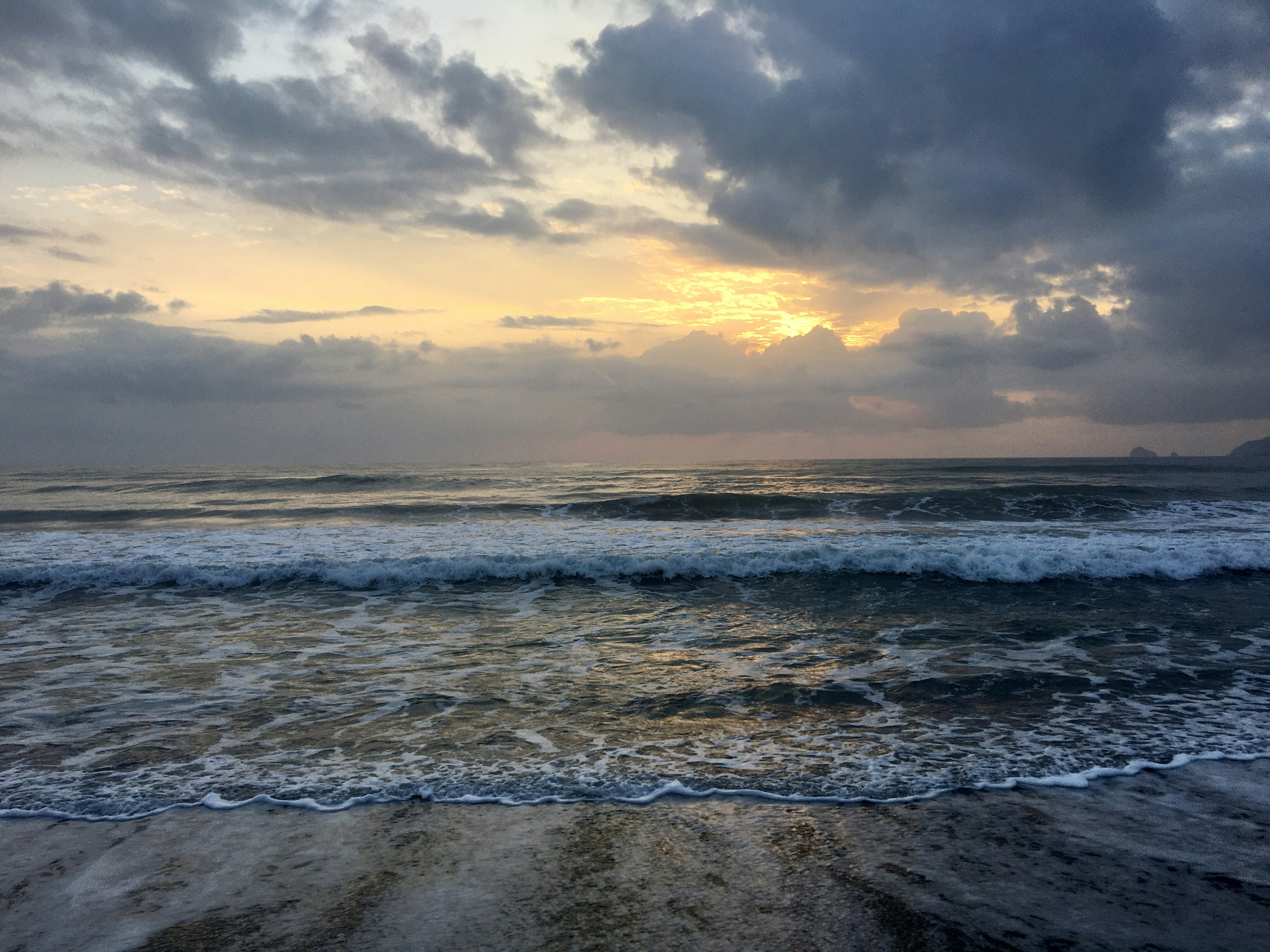 The sun is setting over the ocean waves