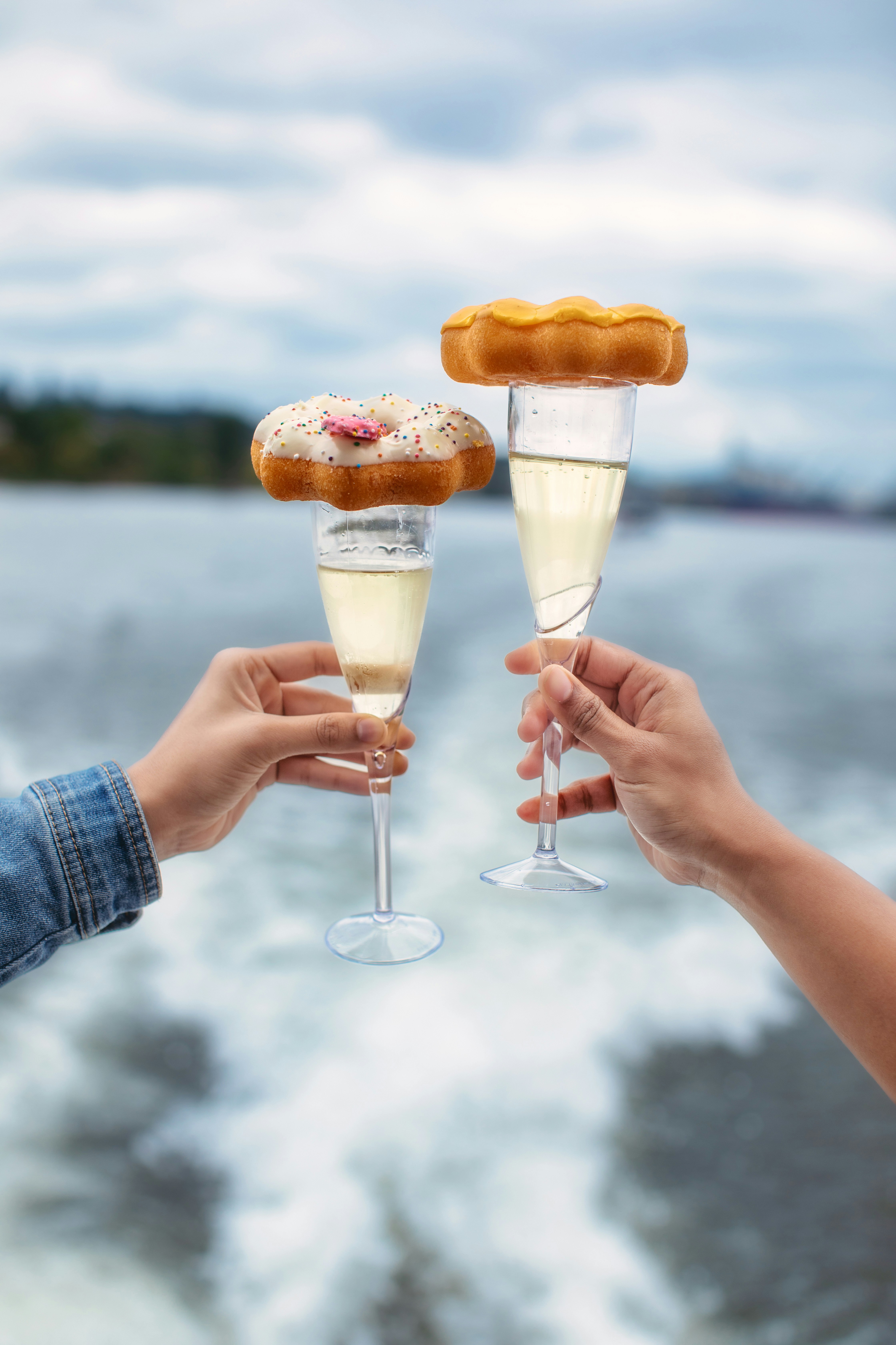 A couple of people holding wine glasses filled with food