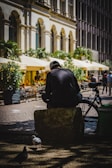A man sitting on a bench next to a bird
