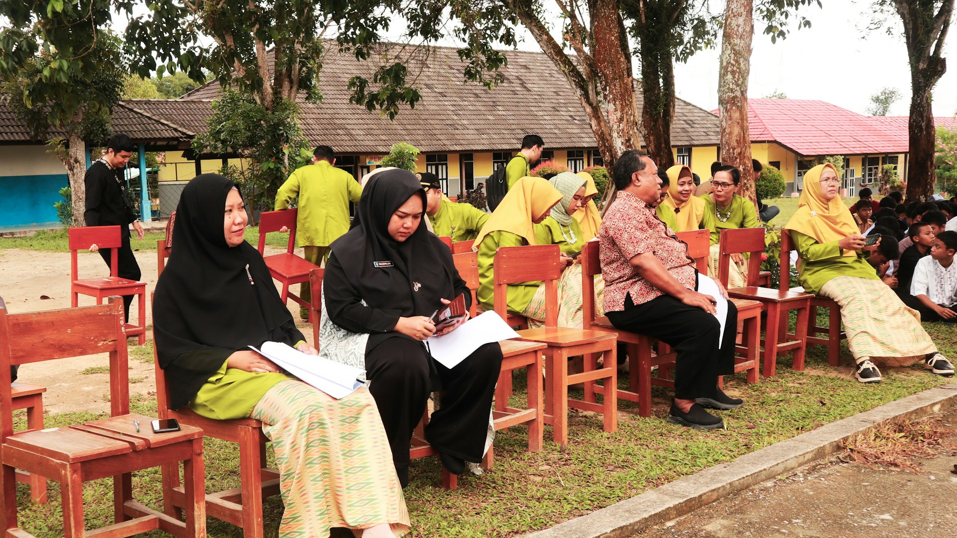 A group of people sitting on top of wooden chairs