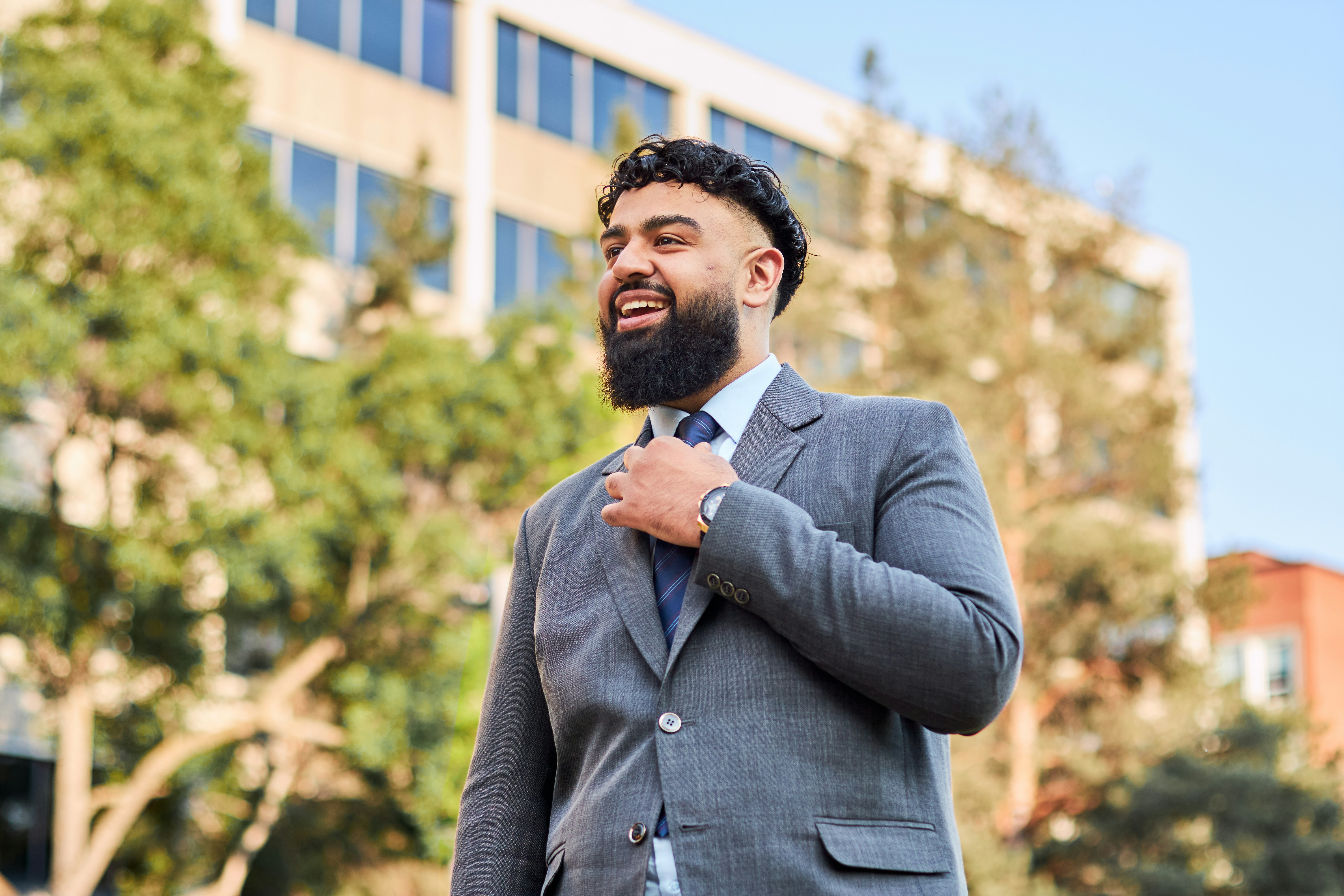 A man in a suit and tie standing in front of a building