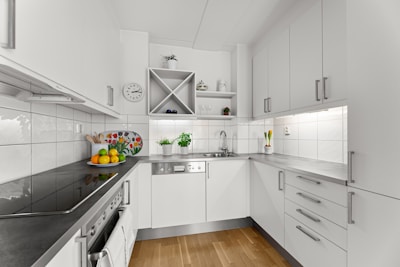 A kitchen with white cabinets and black counter tops