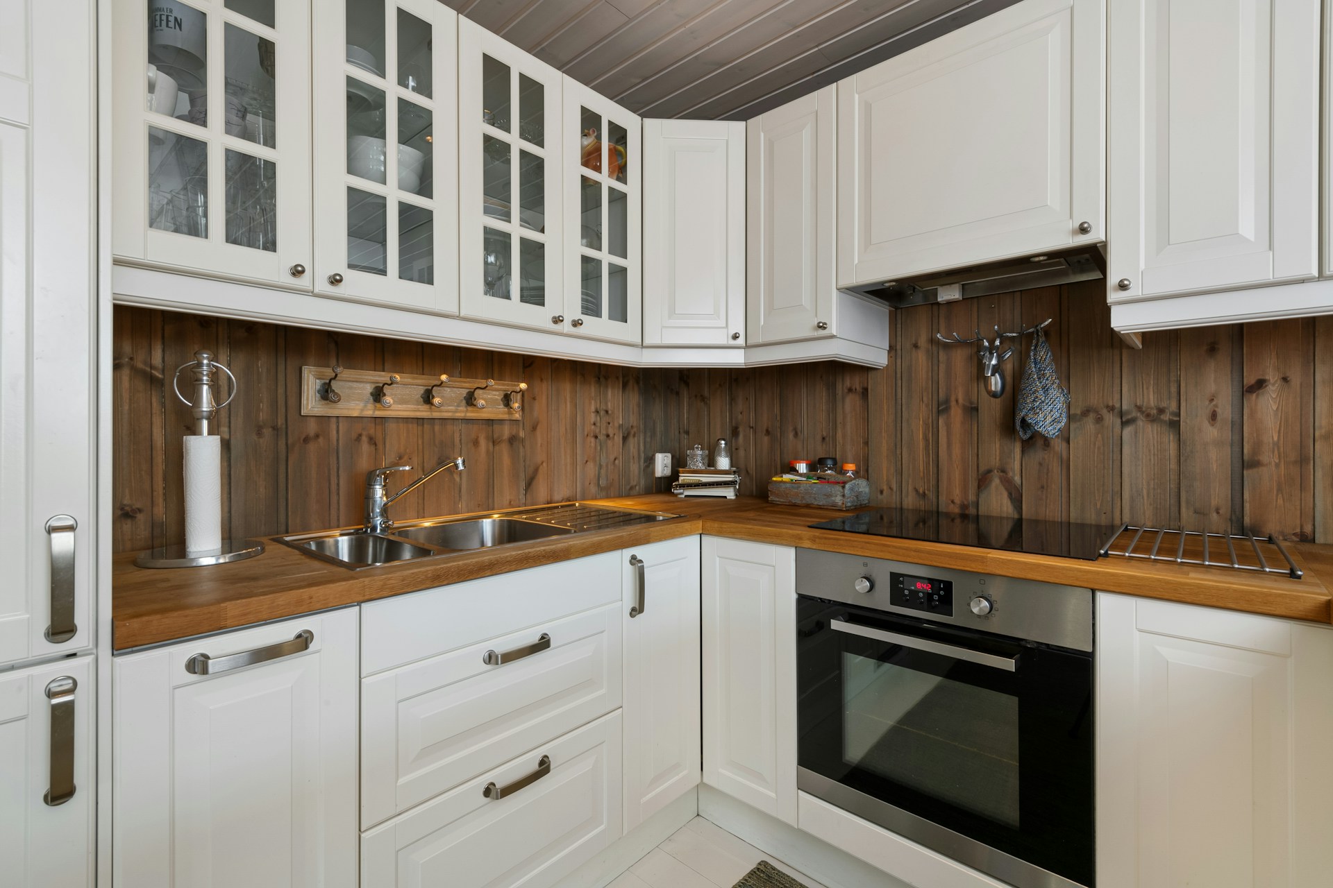 A kitchen with white cabinets and wooden counter tops
