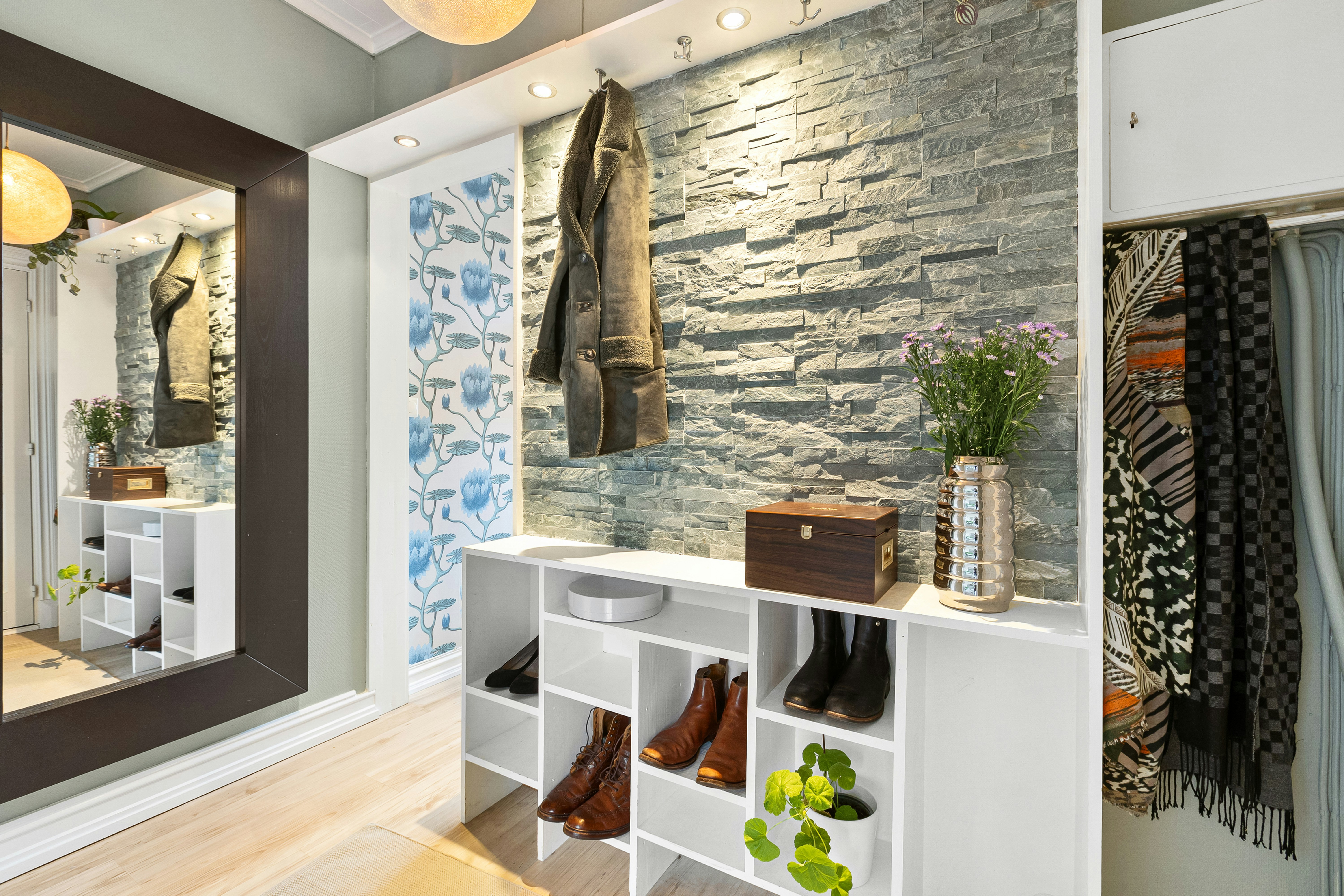 A neatly organized walk-in closet with color-coded clothing, clear storage bins on shelves, and a tidy floor space.