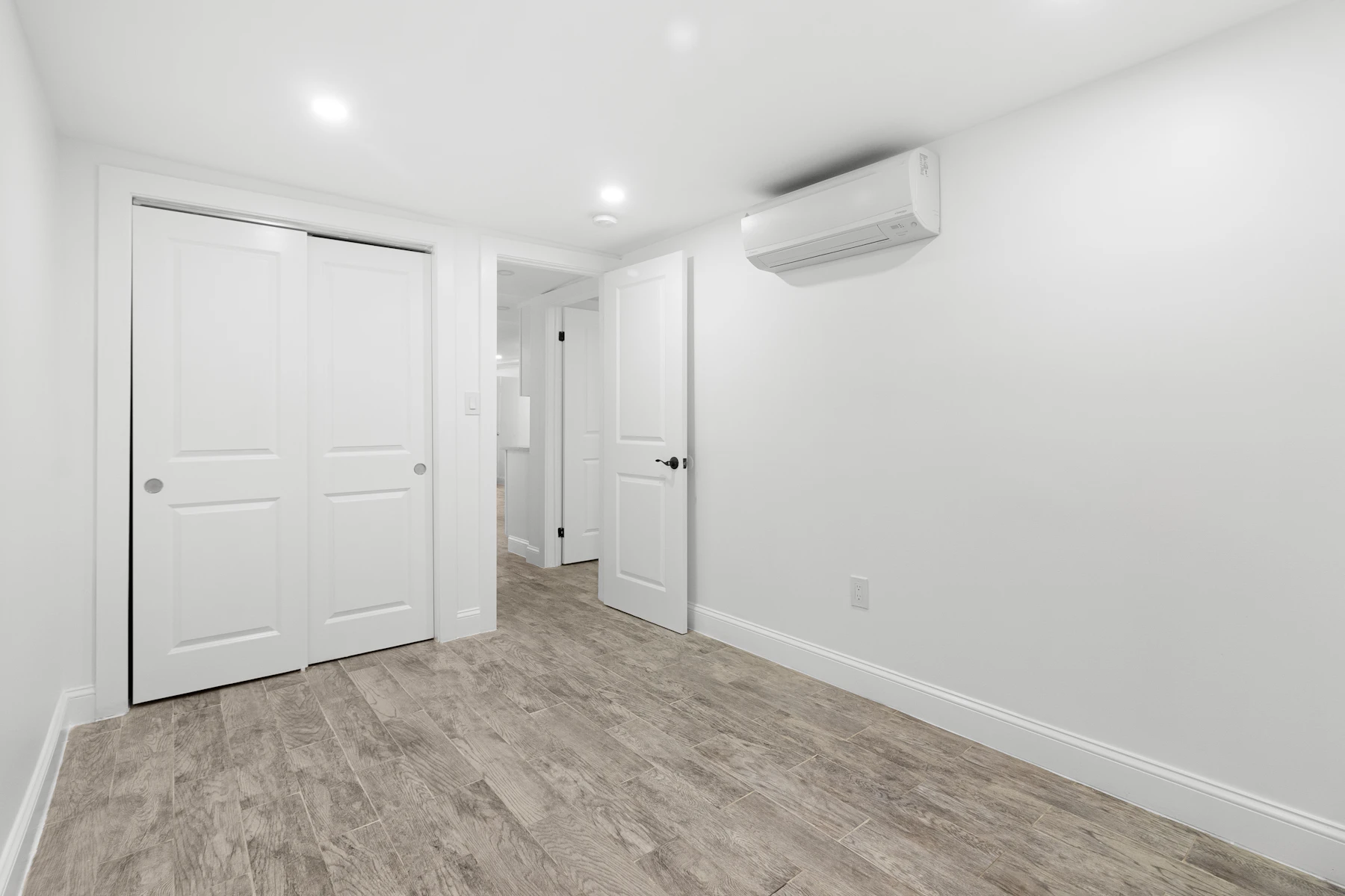 Empty interior with white walls and dark wood flooring