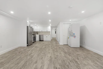 An empty room with a refrigerator and a refrigerator freezer