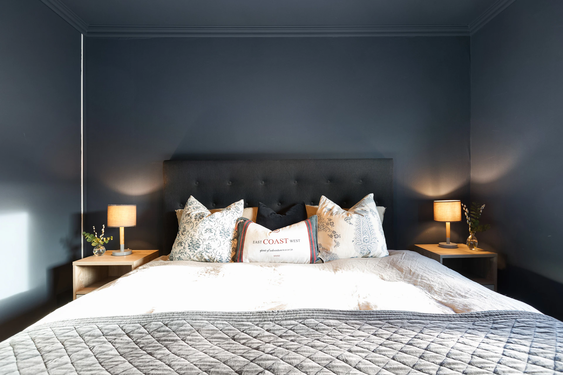 A bedroom with a bed and two lamps