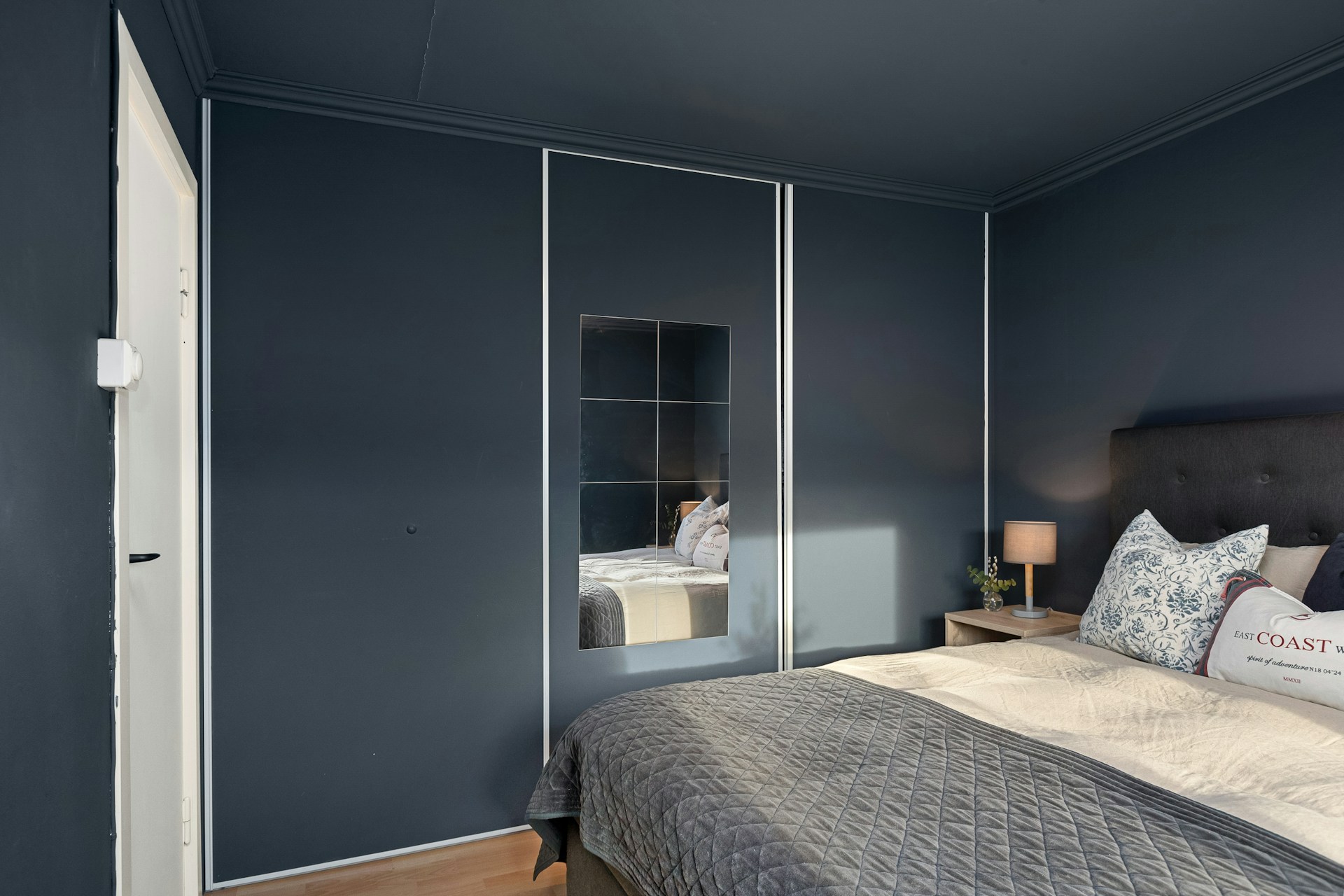 A bedroom with a large bed and blue walls