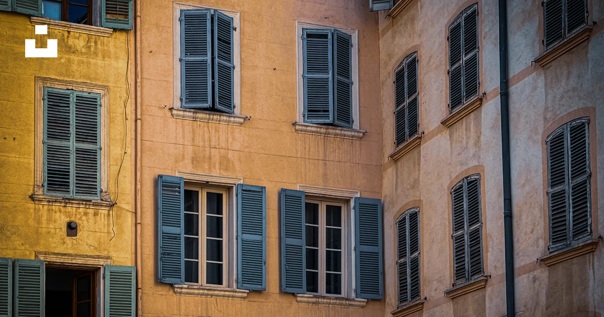 A tall building with lots of windows and shutters photo – Free ...