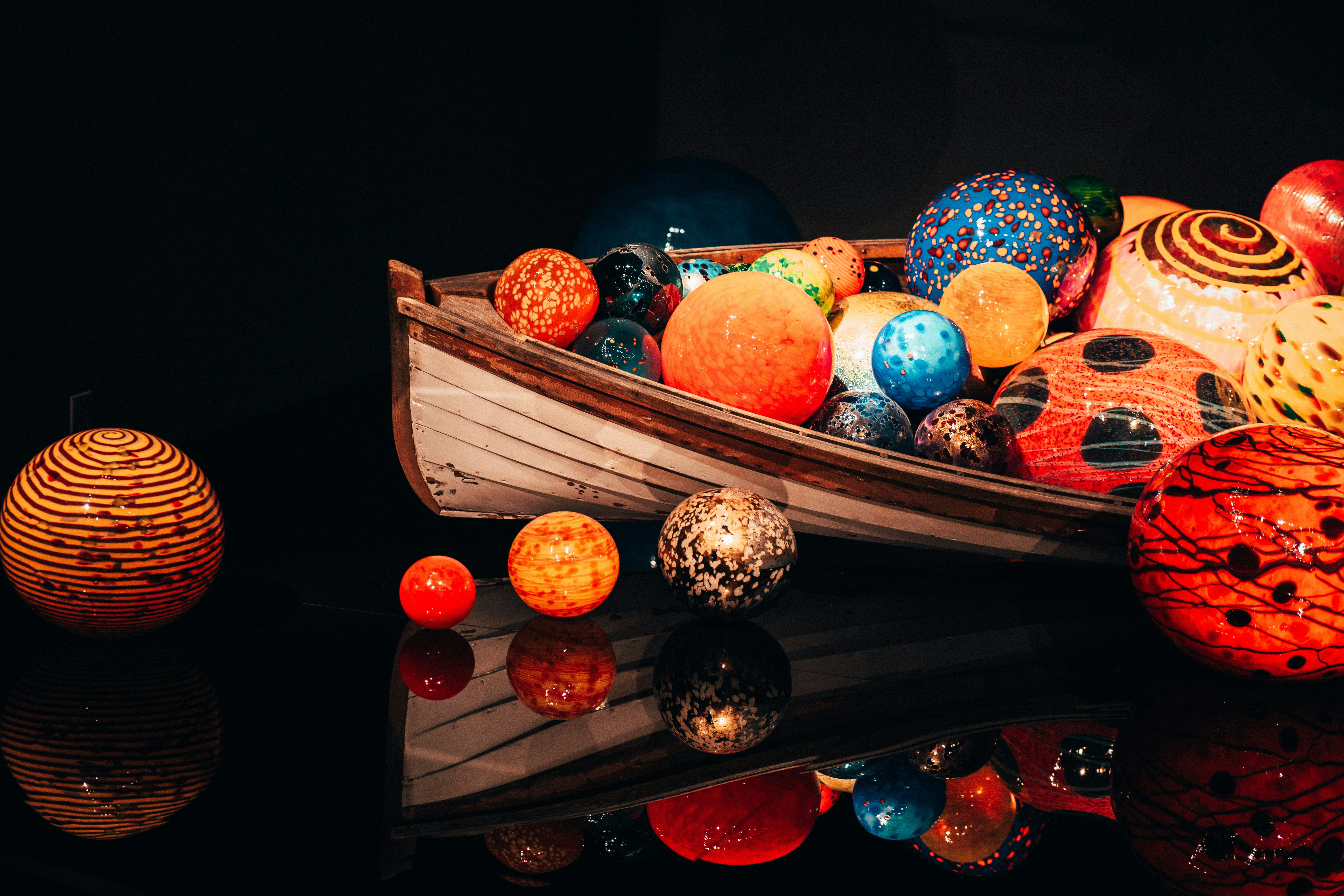 A boat filled with lots of different colored balls