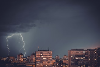 A lightning strikes over a city at night