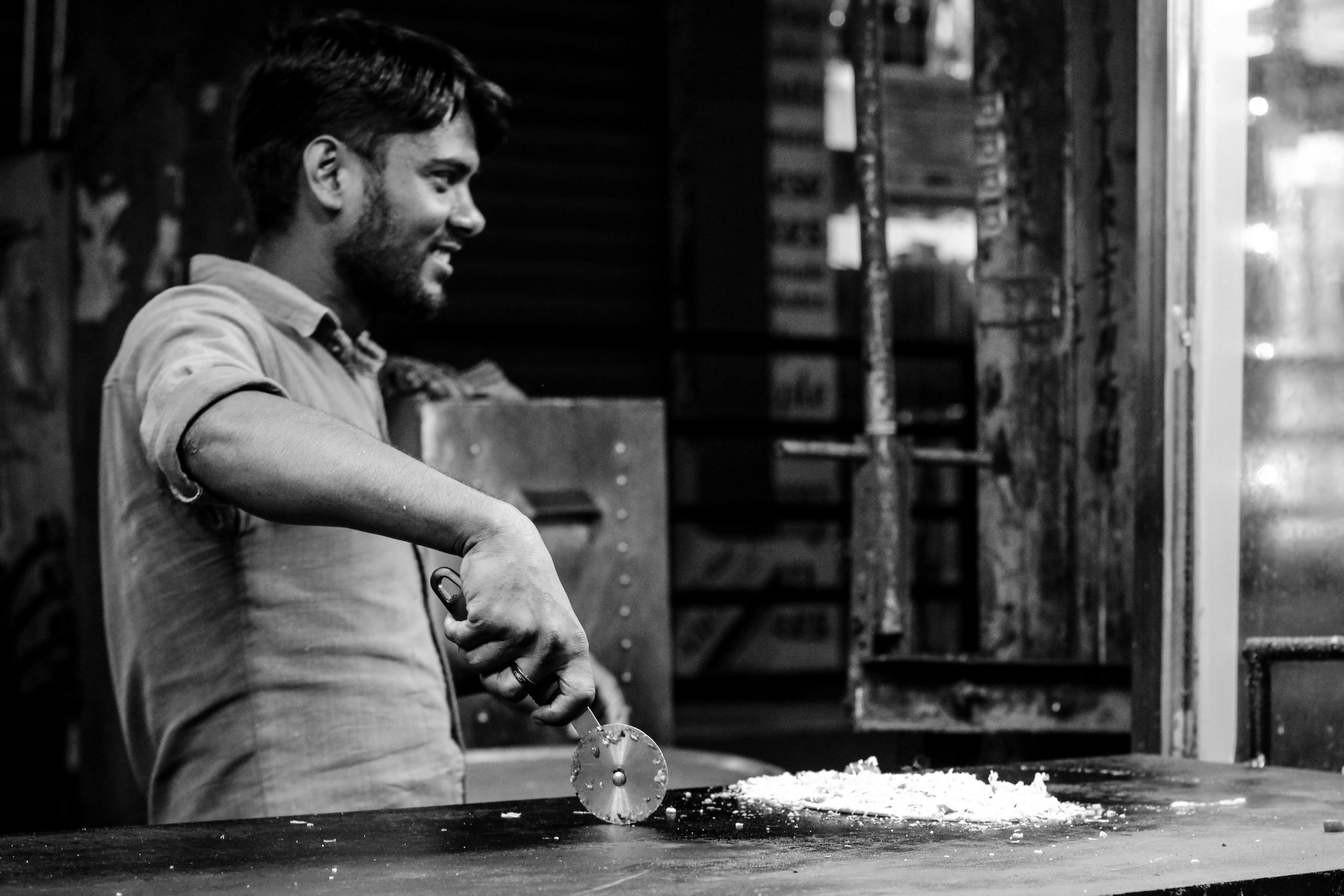 Un hombre de pie frente a un mostrador preparando comida