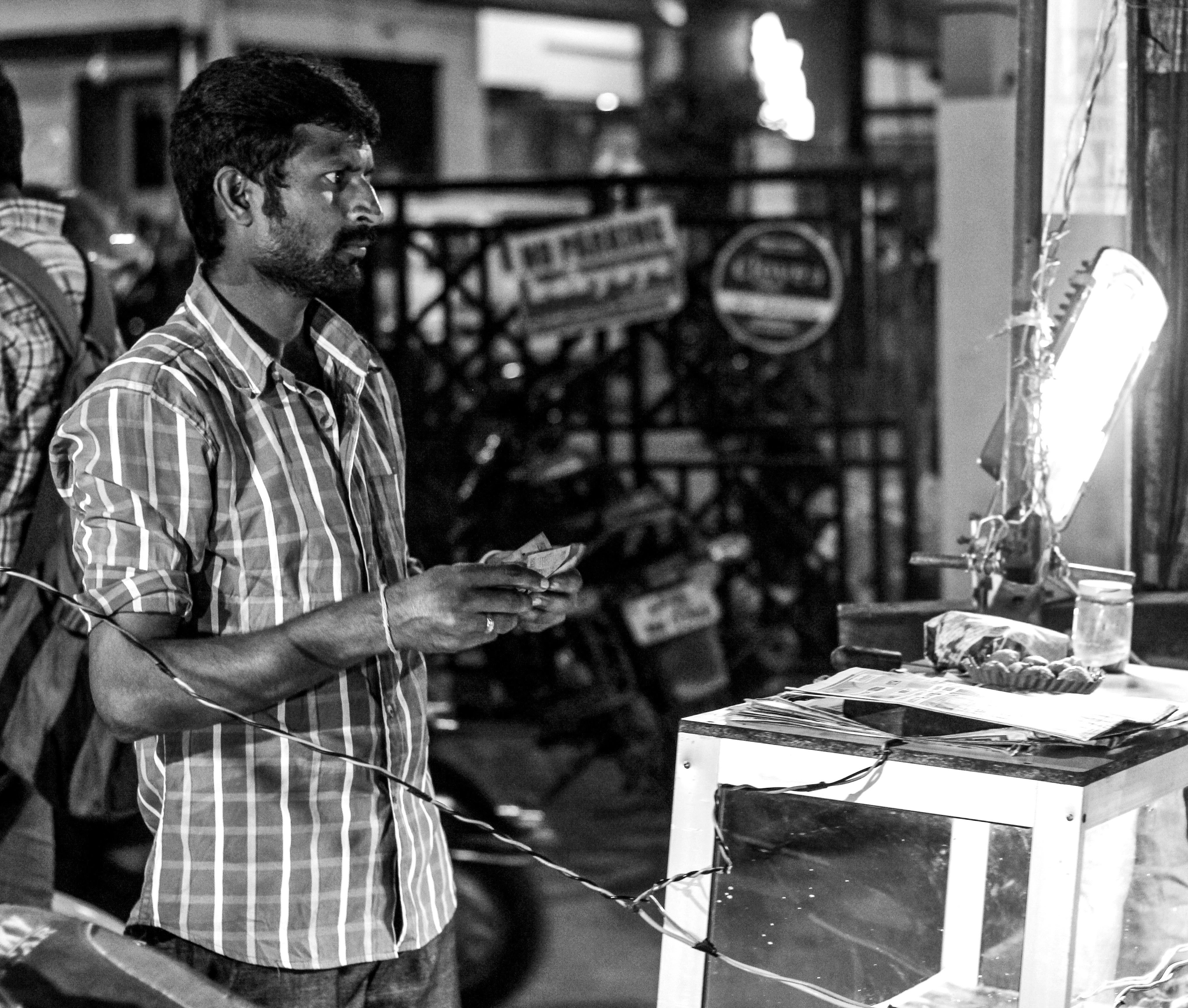 Una foto en blanco y negro de un hombre parado frente a una tienda