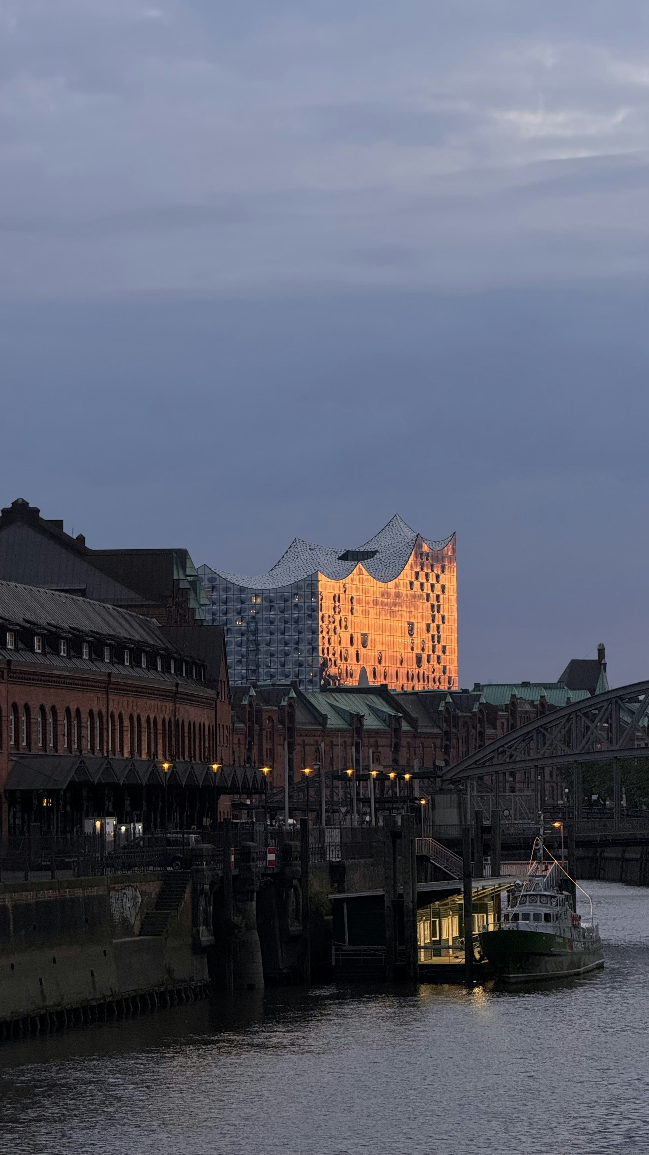 A river with a boat in the water and buildings in the background