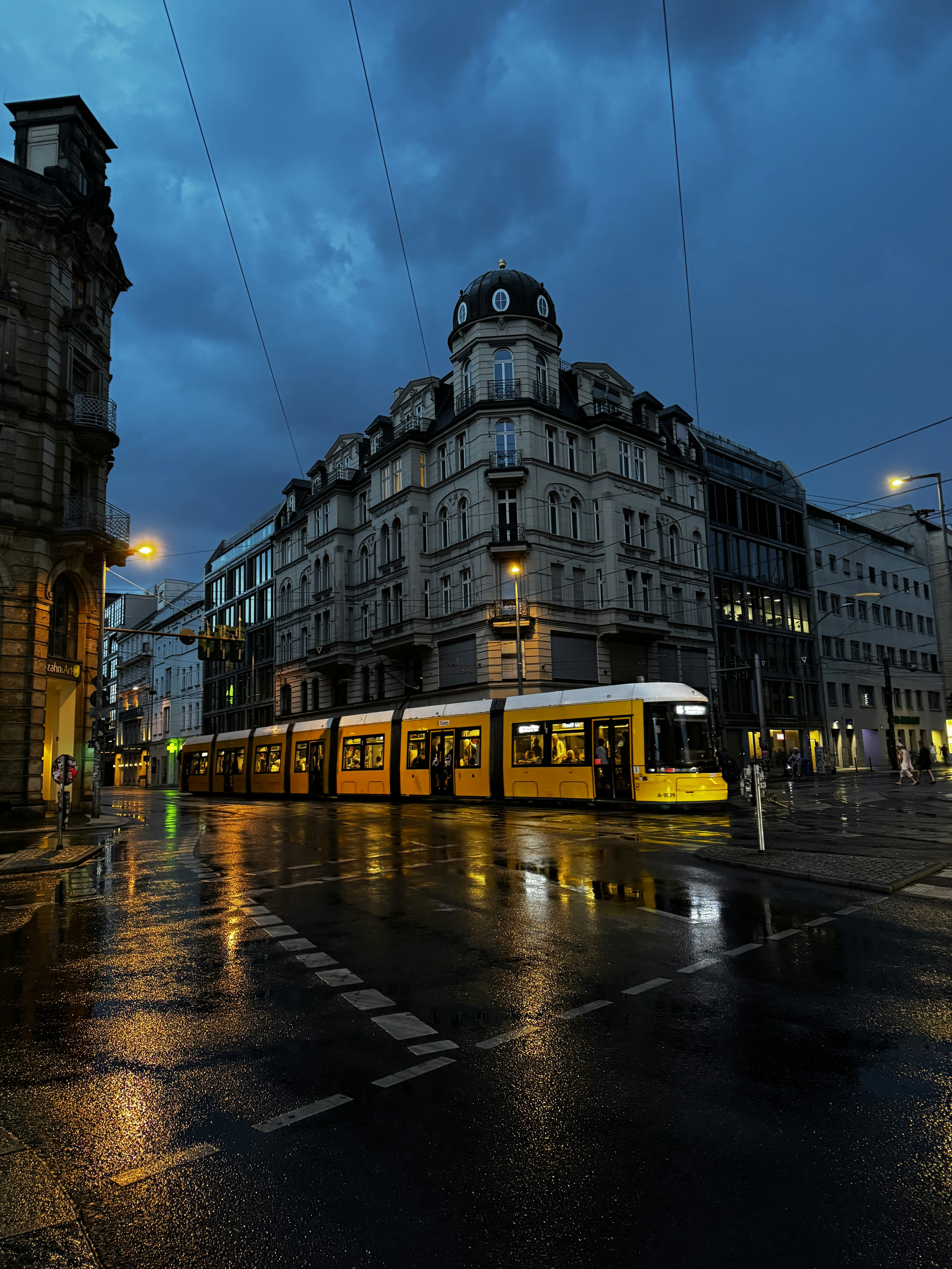 A street scene with a tram on a rainy night