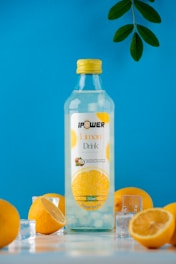 A bottle of lemon water surrounded by lemons