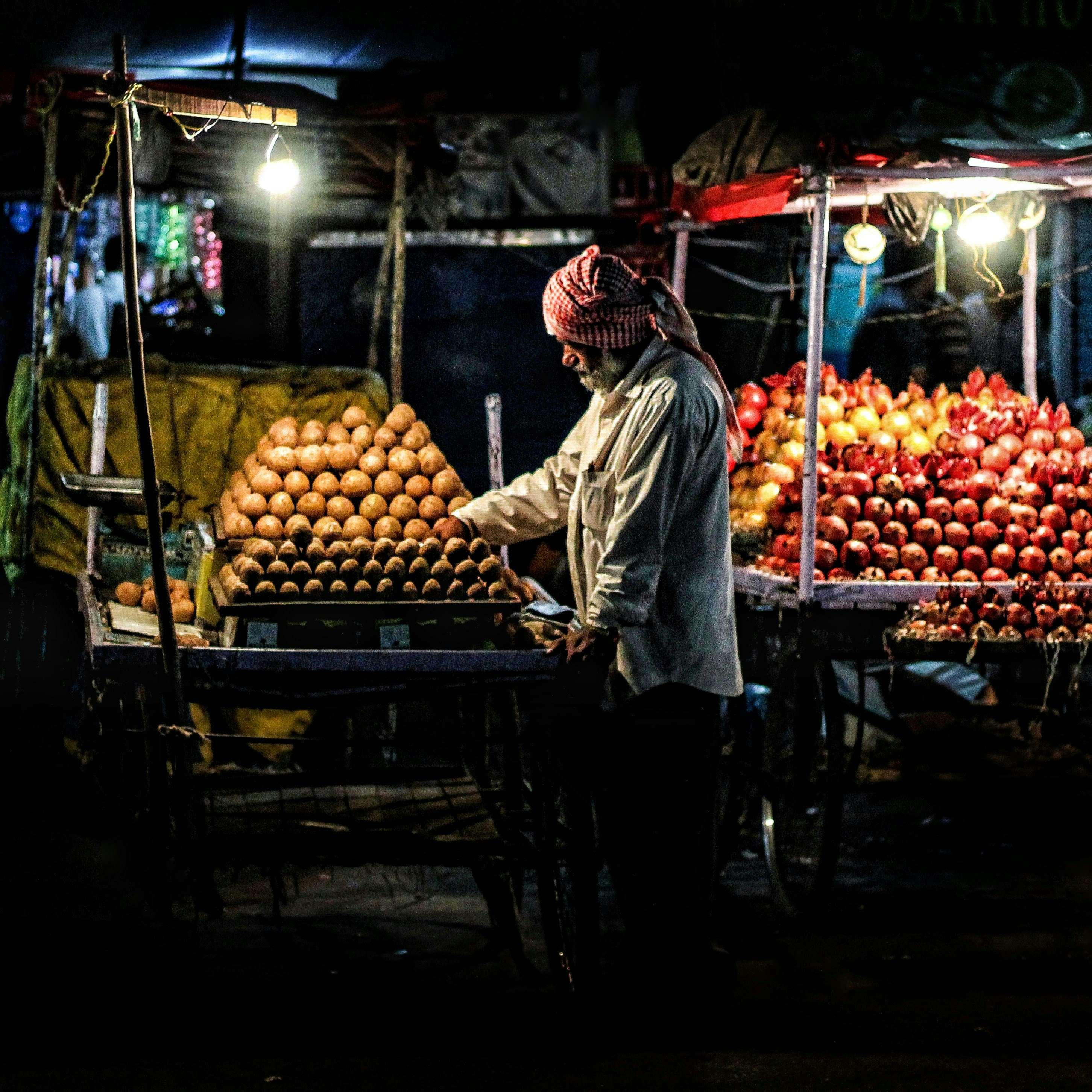 A man standing in front of a fruit stand