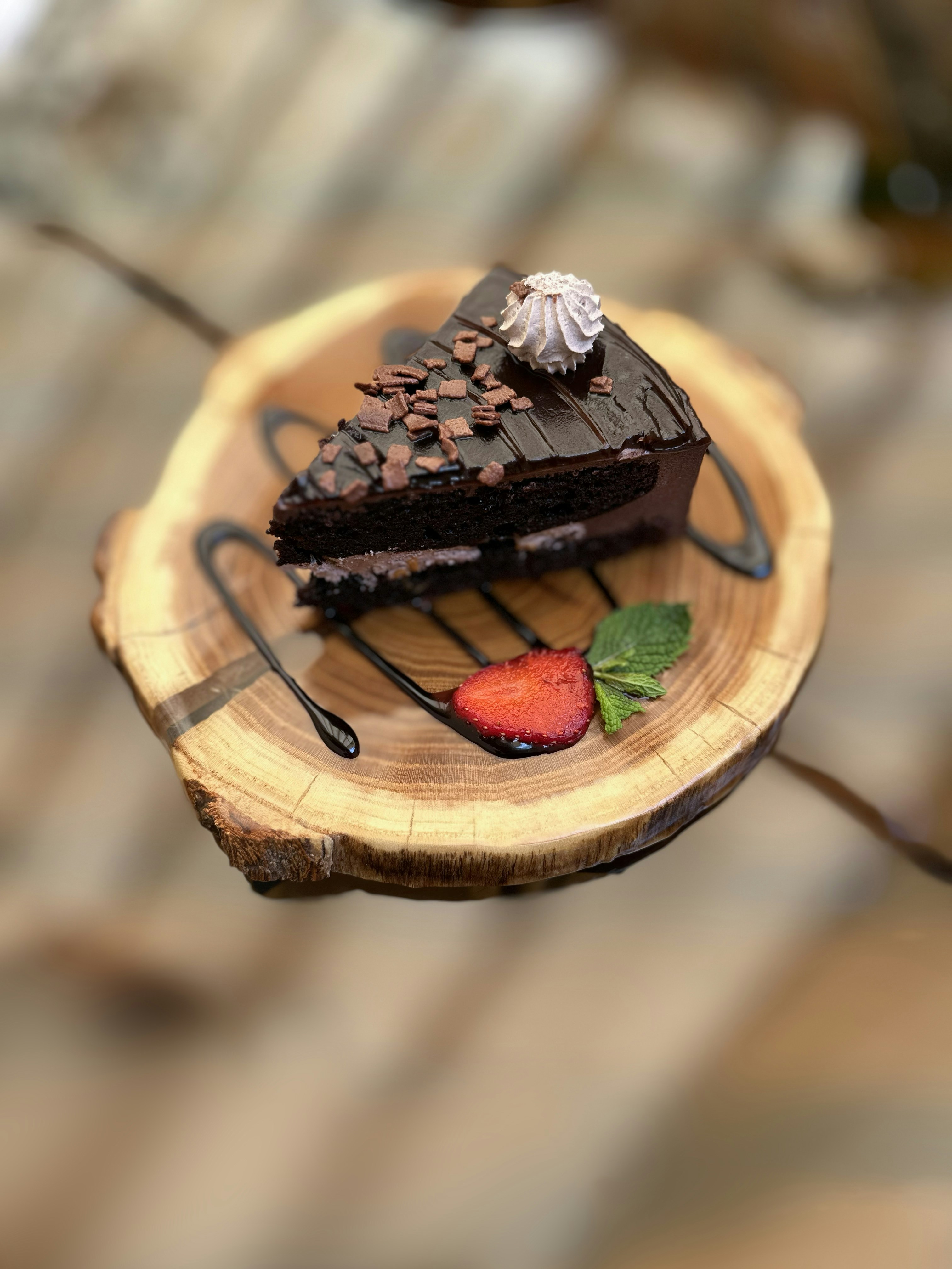 A piece of chocolate cake on a wooden plate