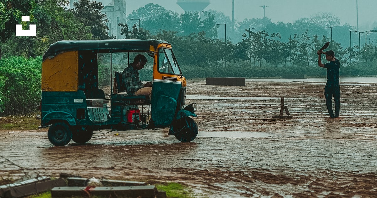 A Man Standing Next To A Golf Cart In The Rain Photo Free Sabarmati a-man-standing-next-to-a-golf-cart-in-the-rain-photo-free-sabarmati