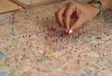 A person is putting pins on a map