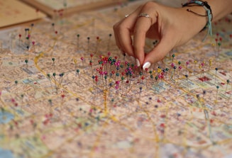 A person is putting pins on a map