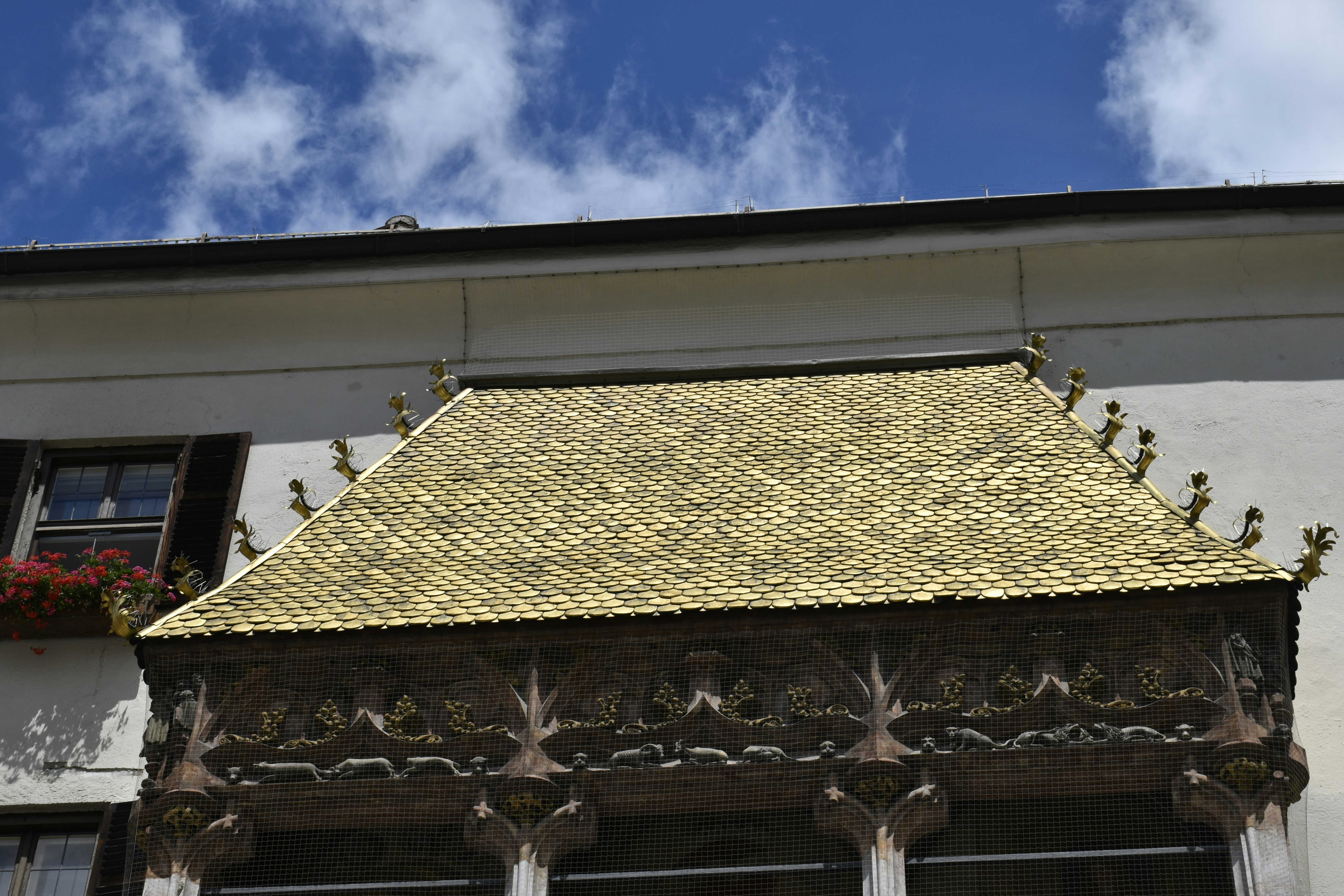 A tall building with a gold roof and windows
