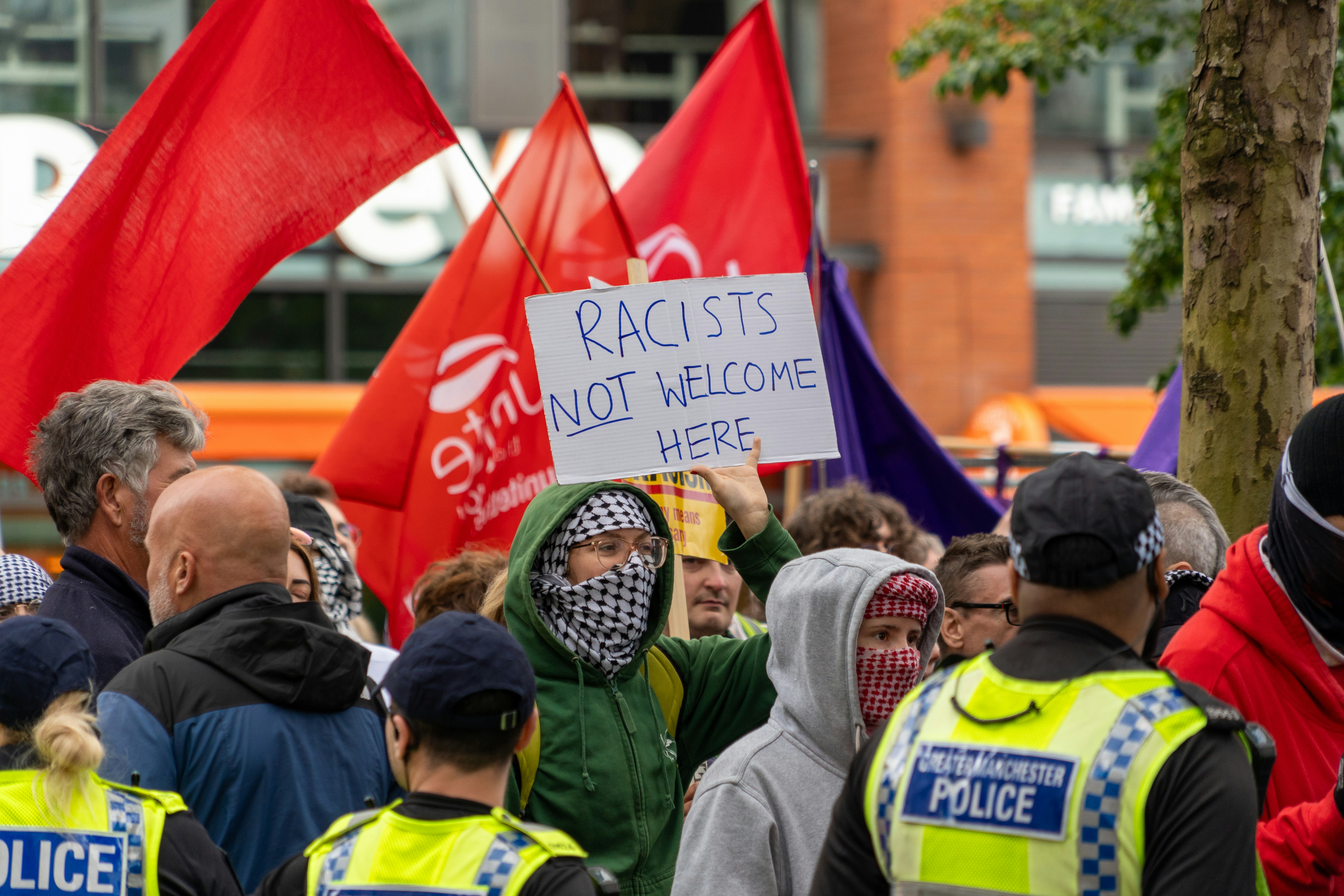 Eine Gruppe von Menschen, die umeinander stehen und Schilder halten