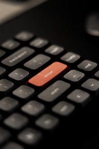 A close up of a keyboard with a red button