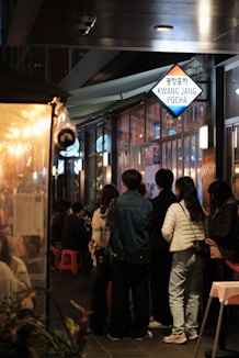 A group of people standing outside of a restaurant