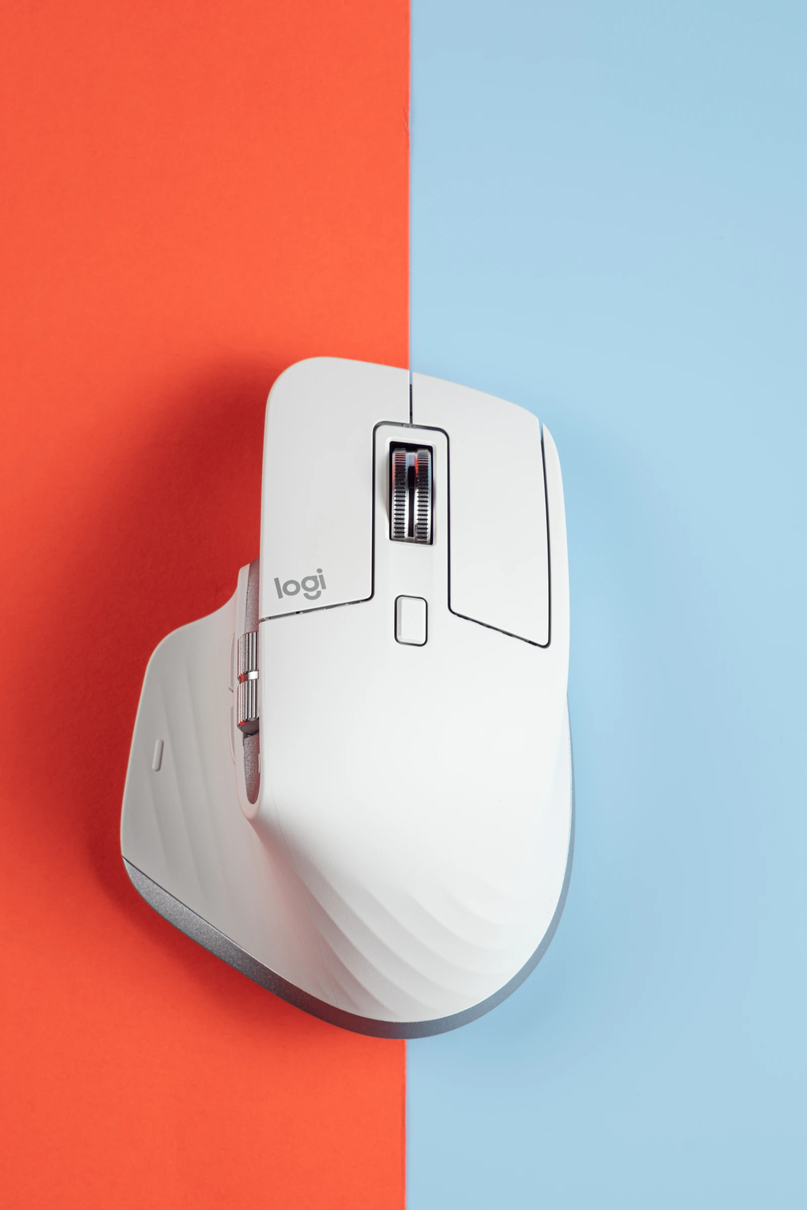 Pale grey Logitech MX Master mouse on red and blue