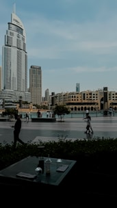A group of people walking across a street next to tall buildings