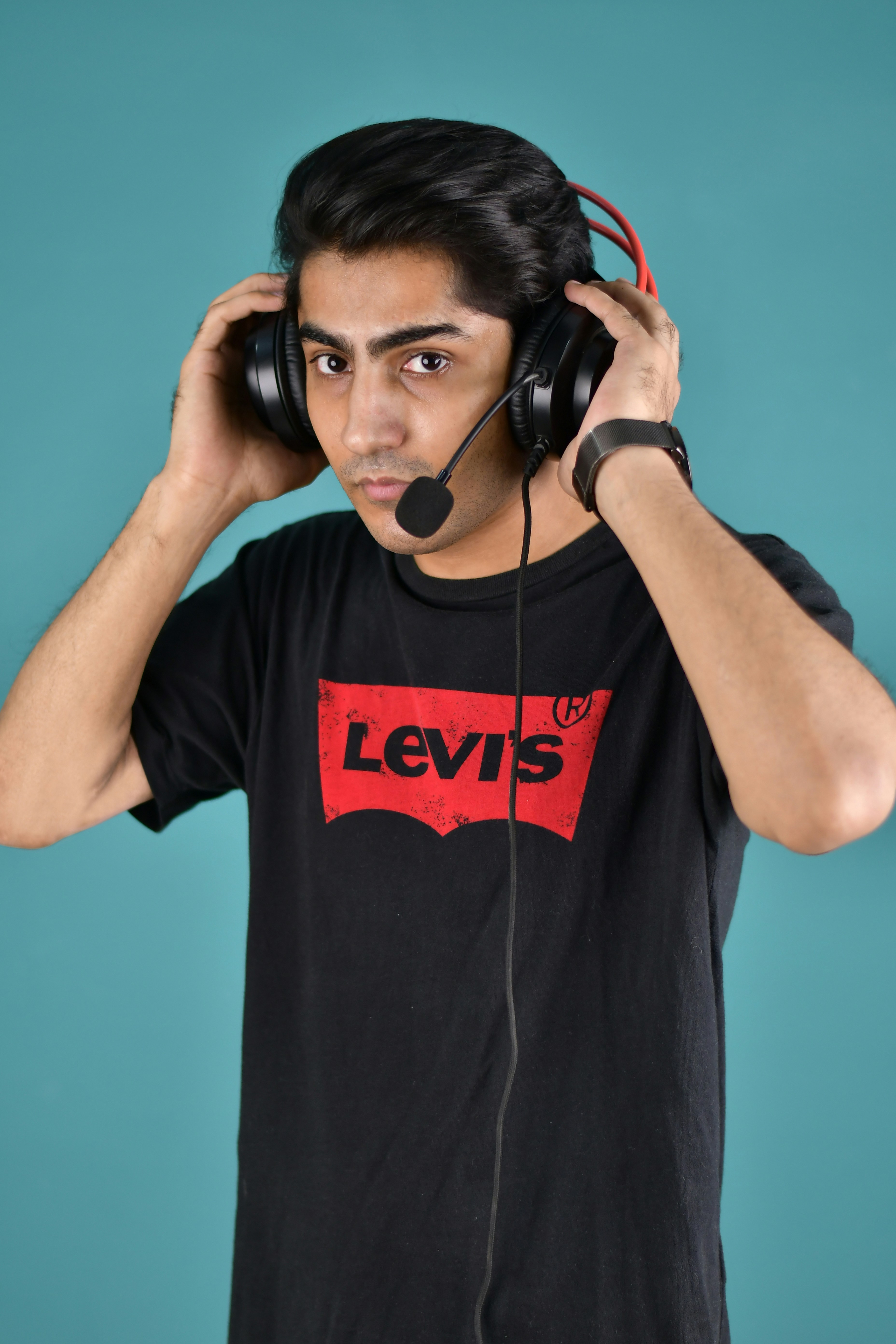 Seorang pria mengenakan headphone dan kaos levis