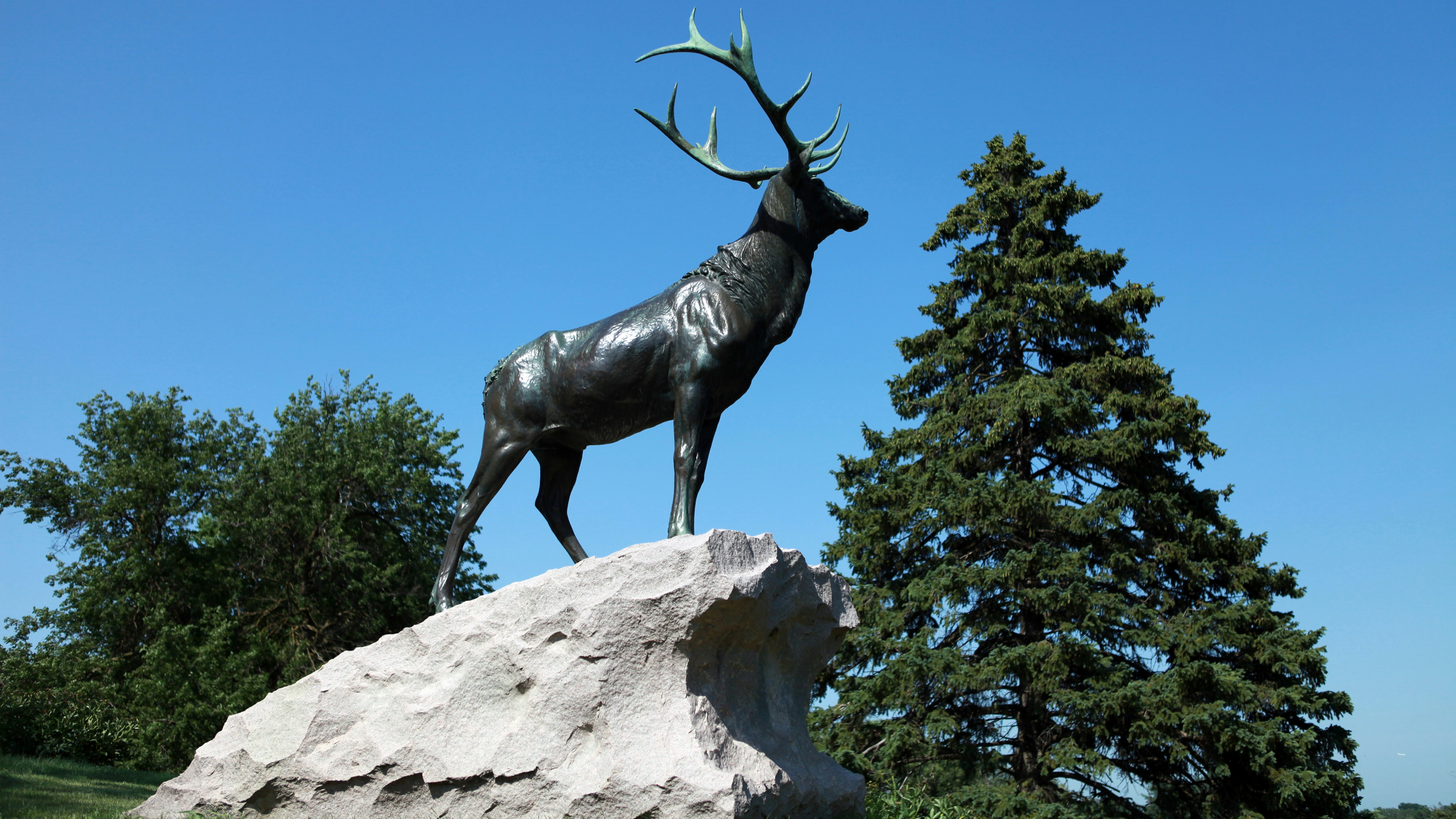 A statue of a deer standing on top of a rock