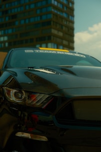 A black sports car parked in front of a tall building