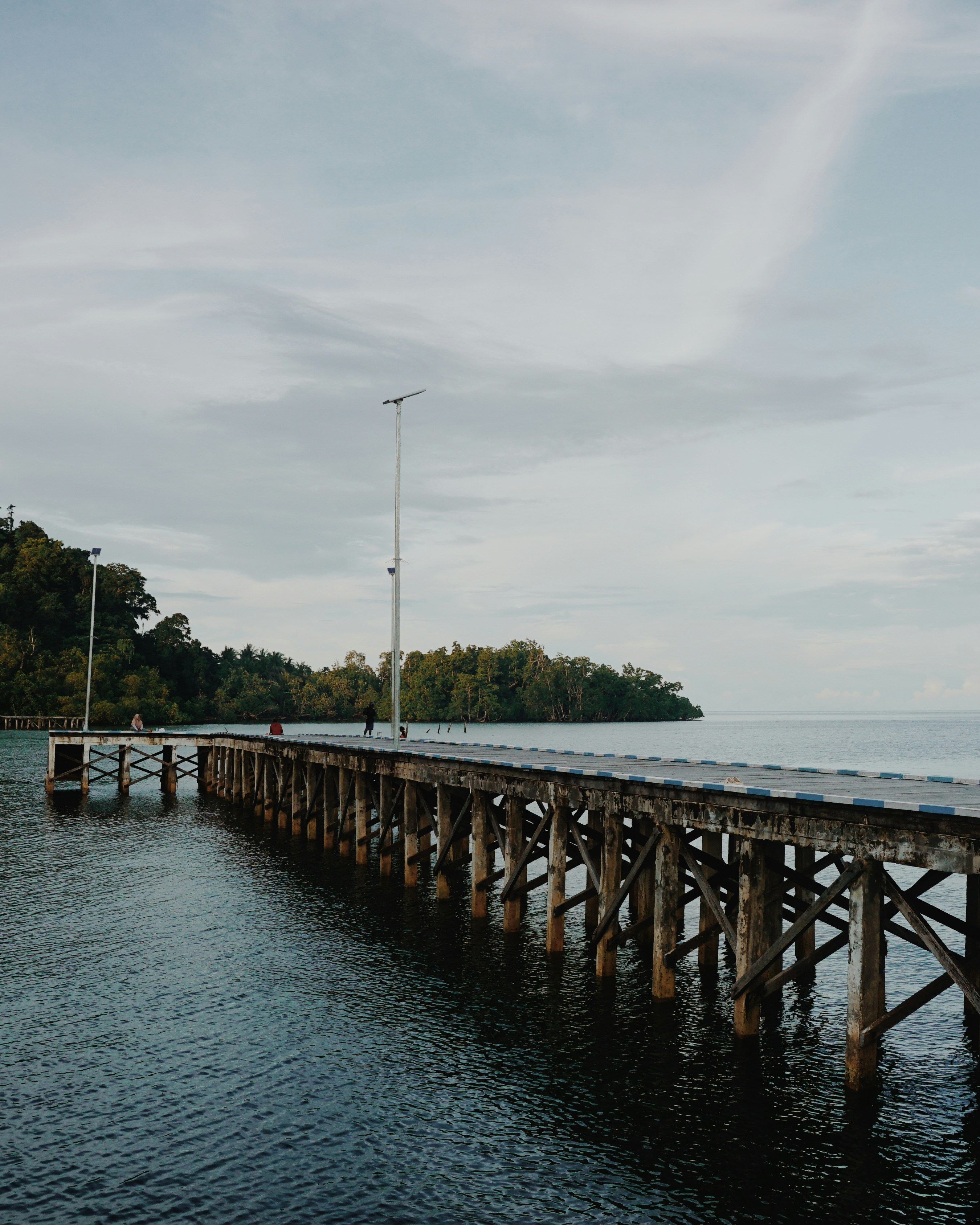 Un largo puente de madera sobre un cuerpo de agua