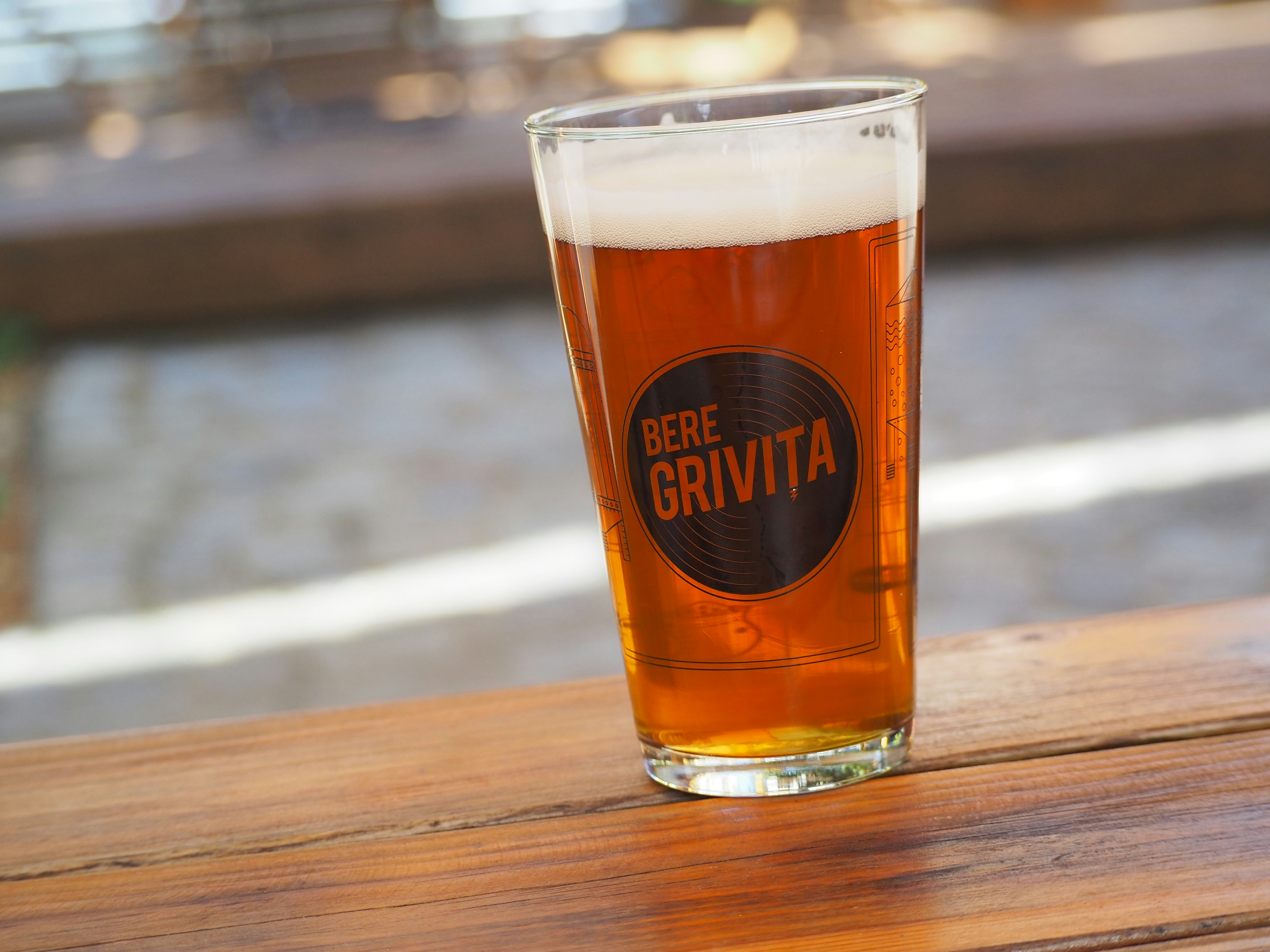 A glass of beer sitting on top of a wooden table