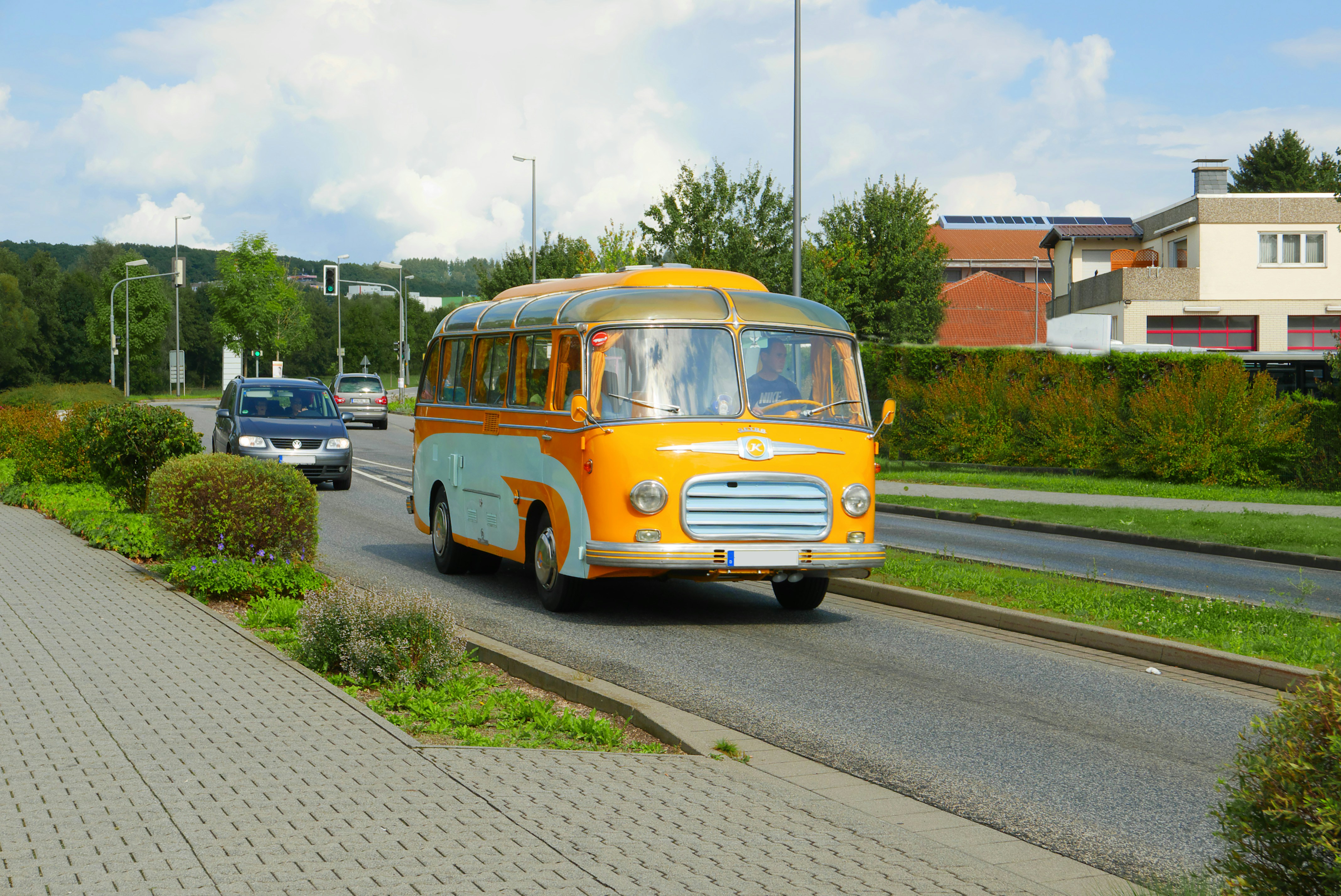 A yellow and blue bus driving down a street