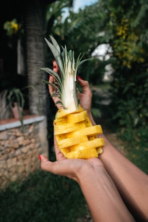 A person holding a pineapple in their hand