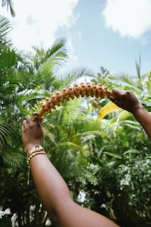 A woman is holding a long piece of food in her hand