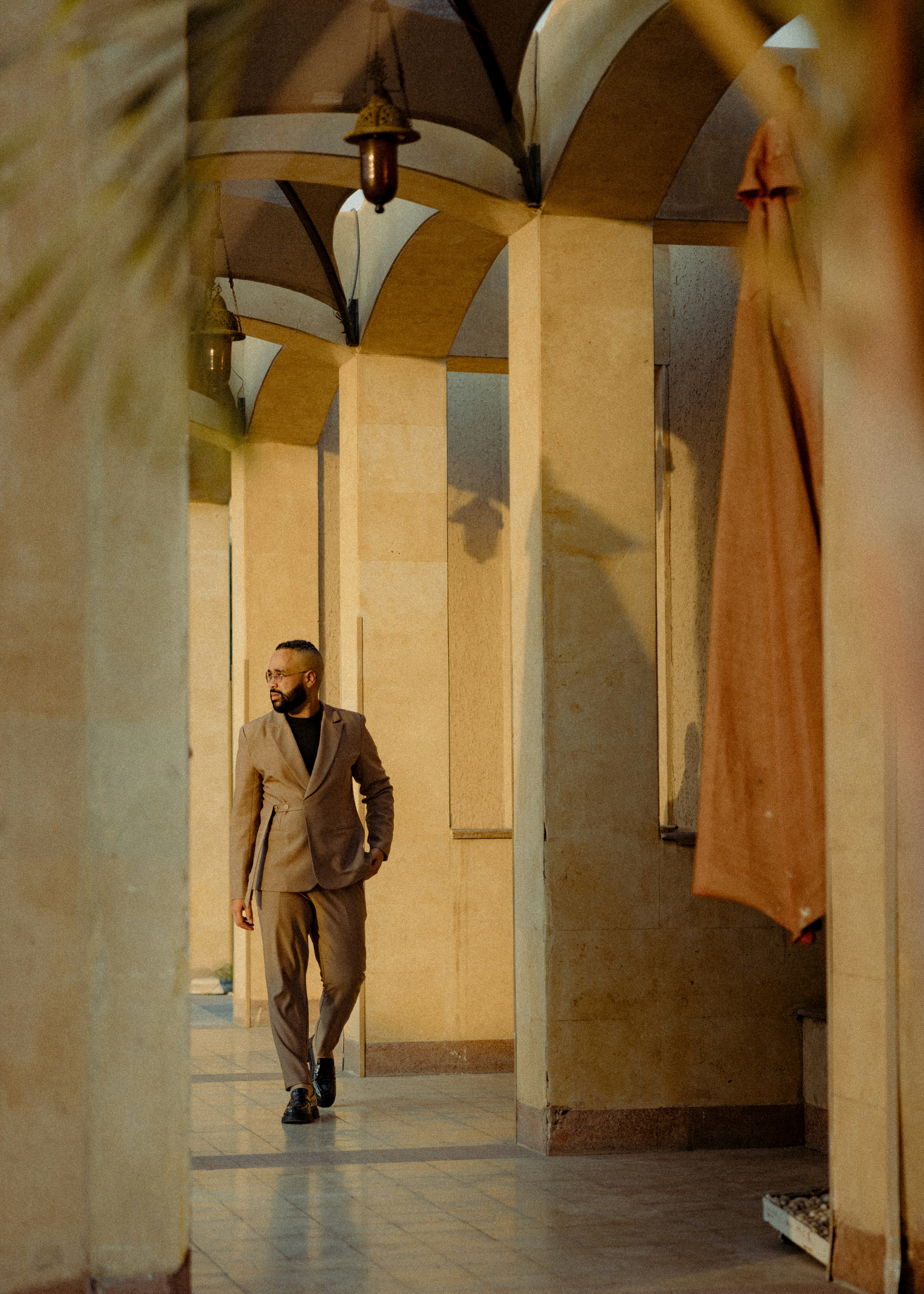 A man in a suit walking down a hallway