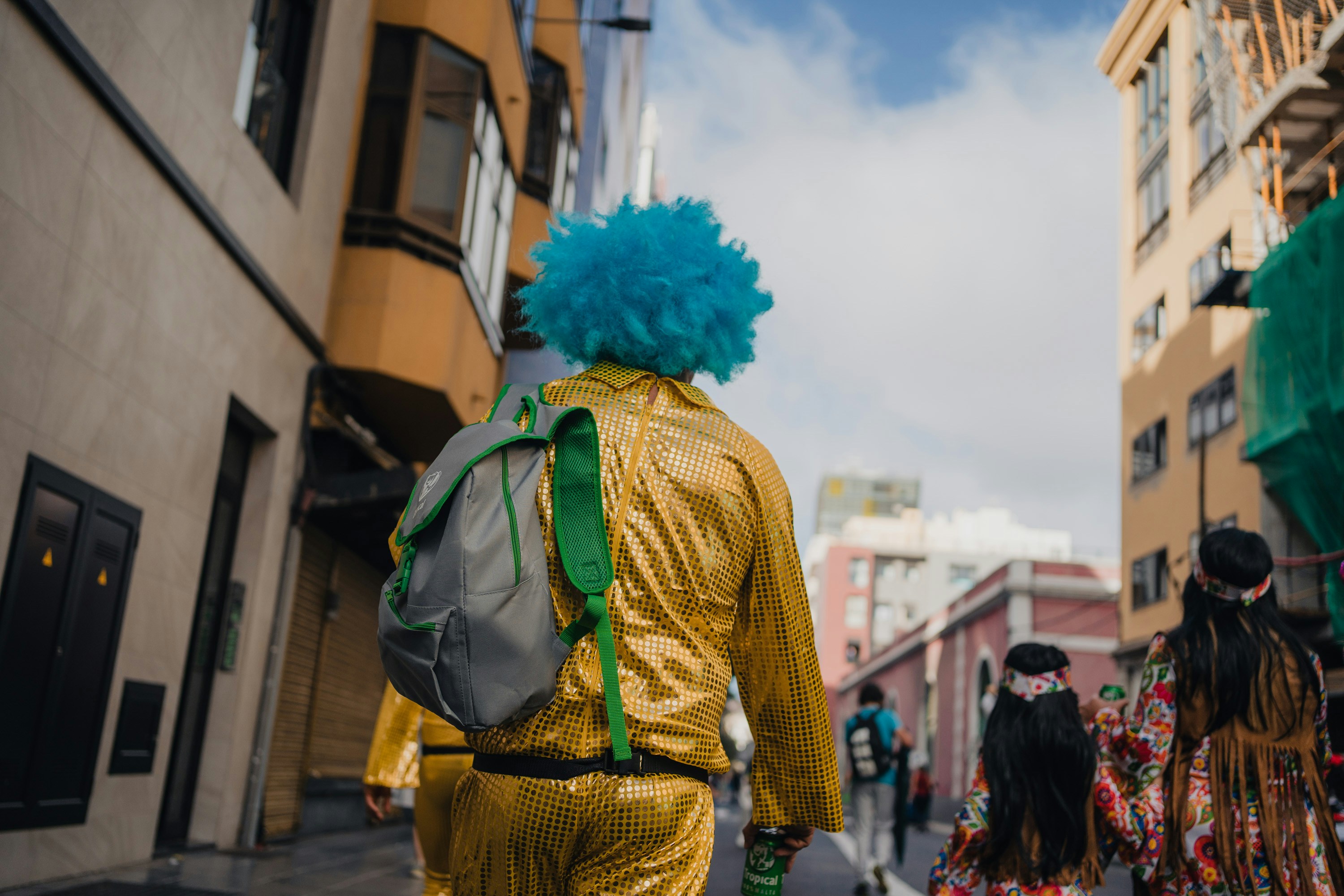A man with blue hair walking down a street