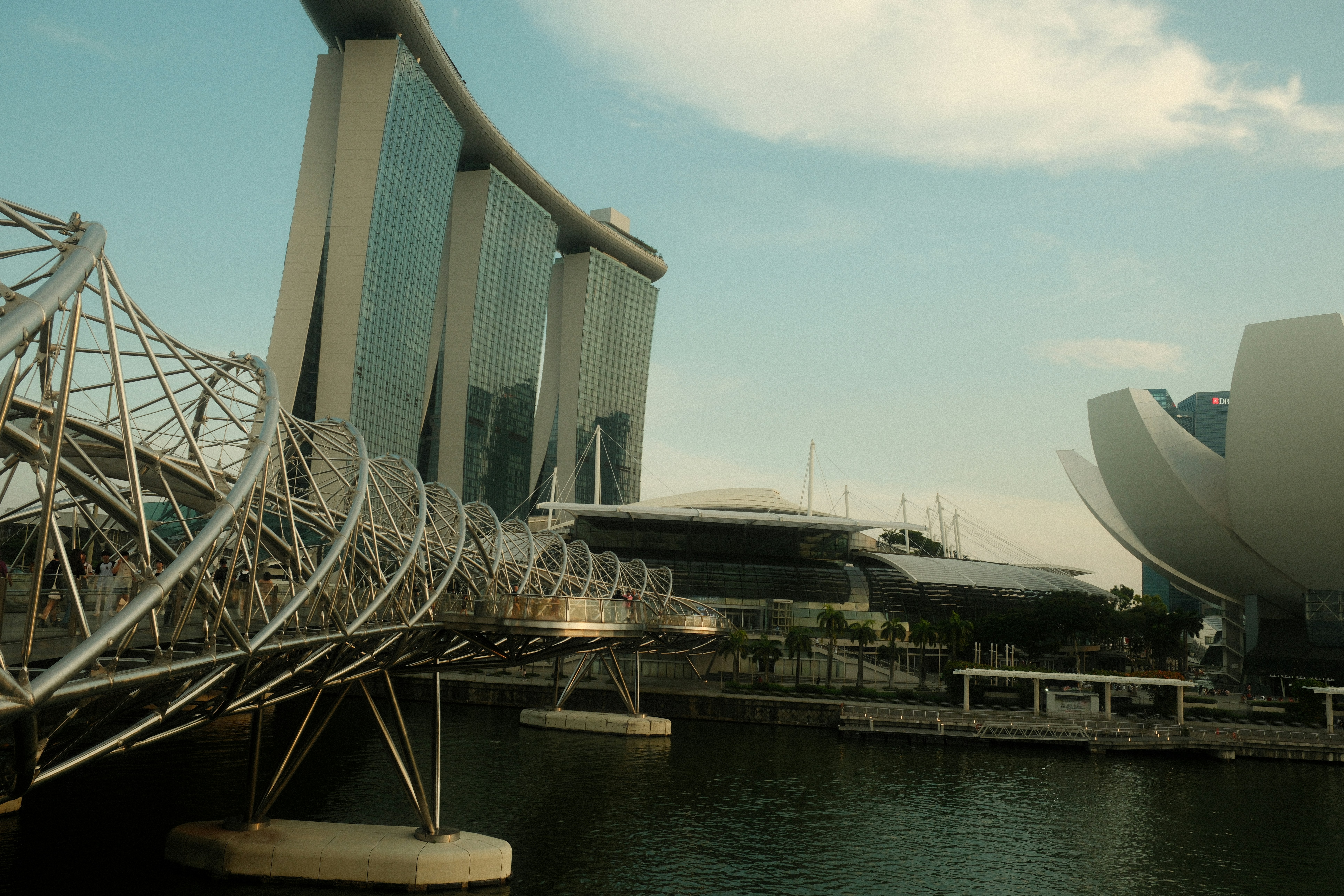 A bridge over a body of water with a building in the background